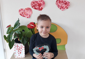 Chłopiec siedzi trzymając serce z puzzli